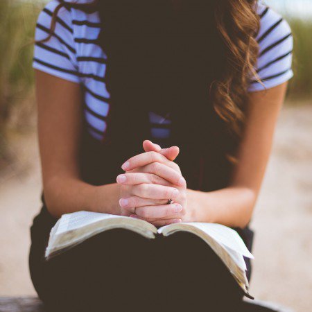 A woman praying over her bible
