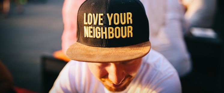 Man with a cap that says Love your neighbour